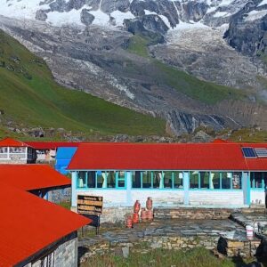 Teahouses with red roofs at Annapurna Base Camp, with the majestic snow-capped Annapurna South peak in the background.