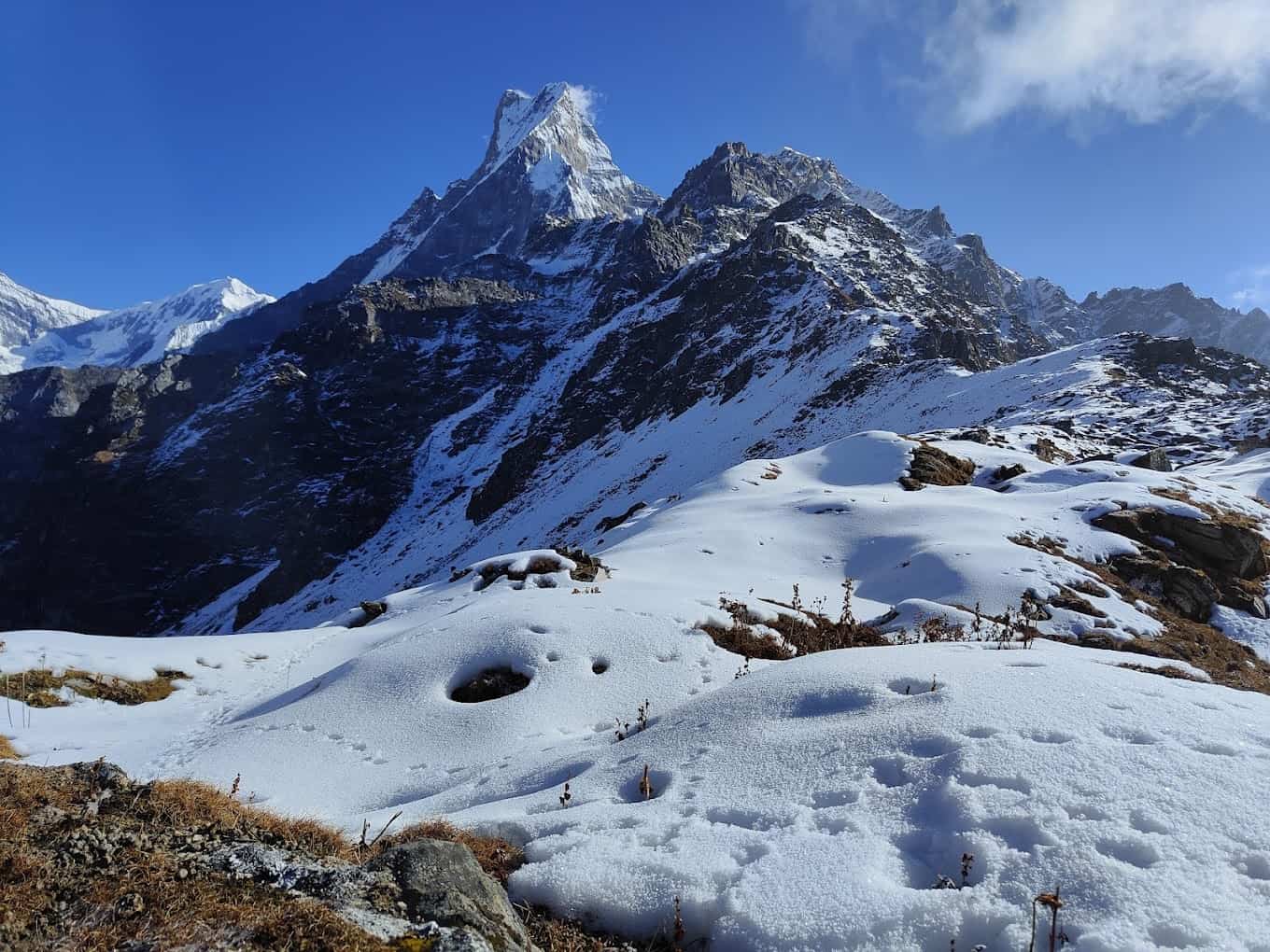 Snow-covered landscape of Mardi Himal with the majestic Machapuchare (Fishtail) peak in the background under a clear blue sky during the Mardi Himal Trek in Nepal.