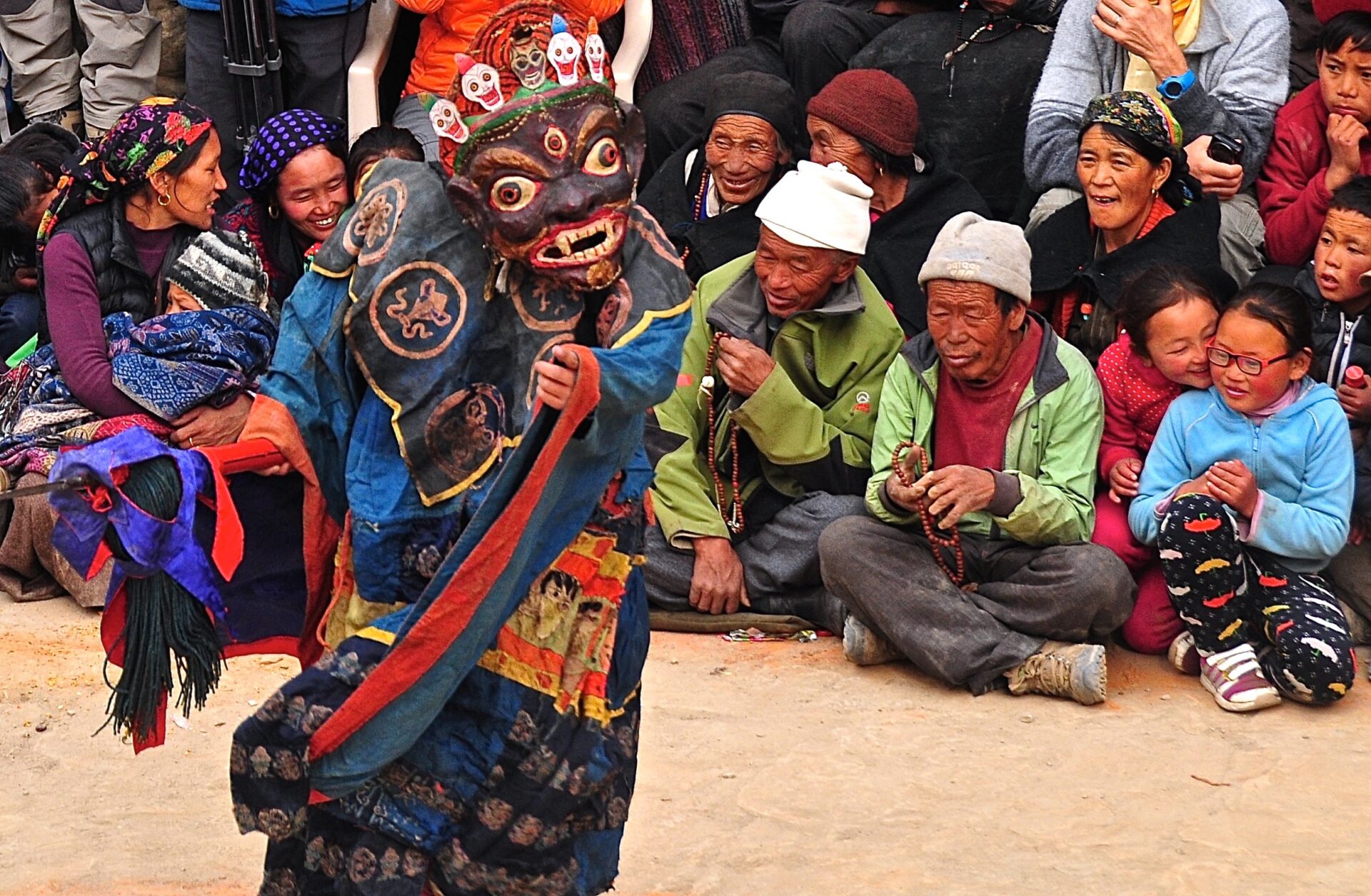 Authentic travel experiences in Nepal – traditional cultural performance with a masked dancer and local audience.